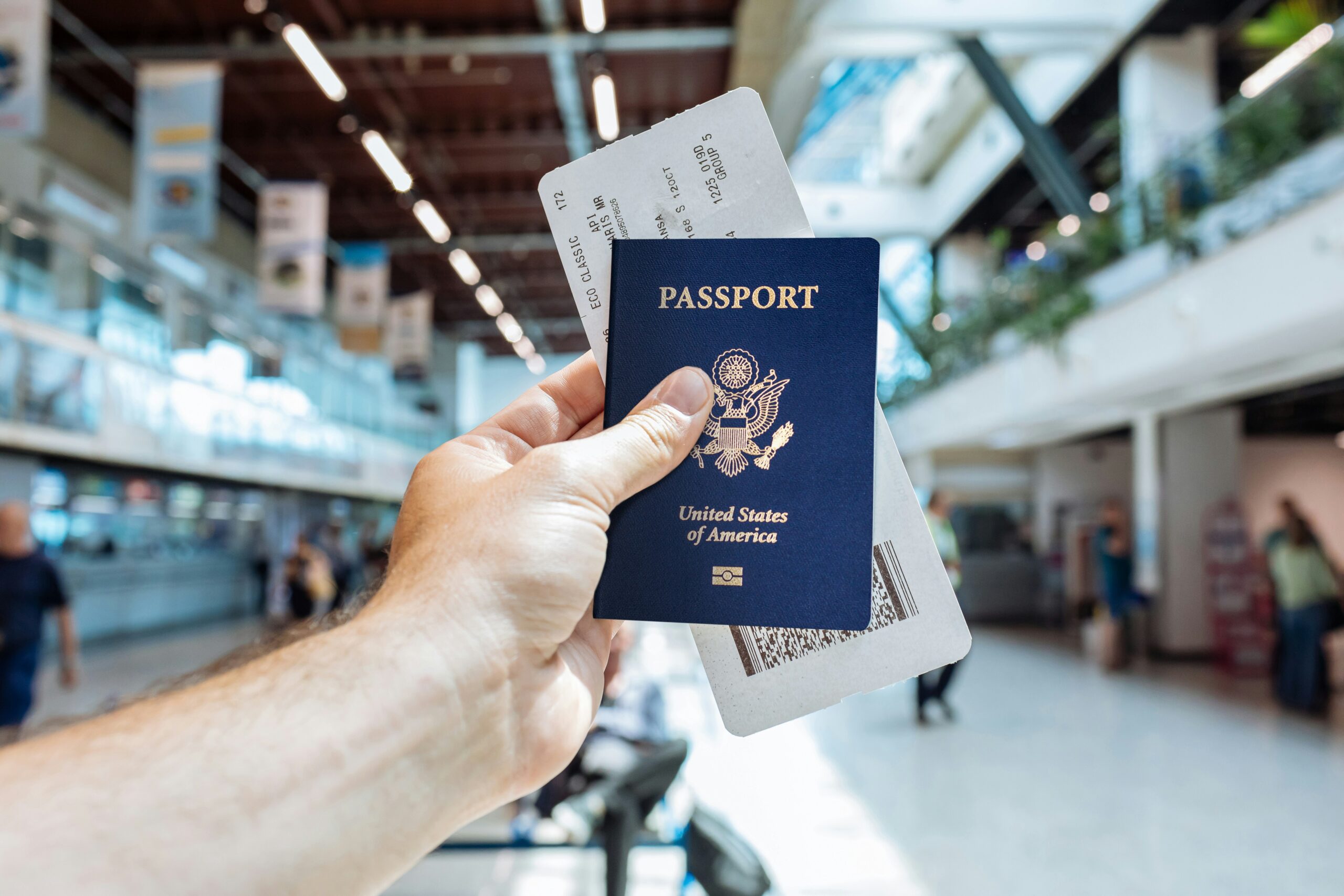 Traveler holding a passport and flight ticket while reviewing booking refund terms