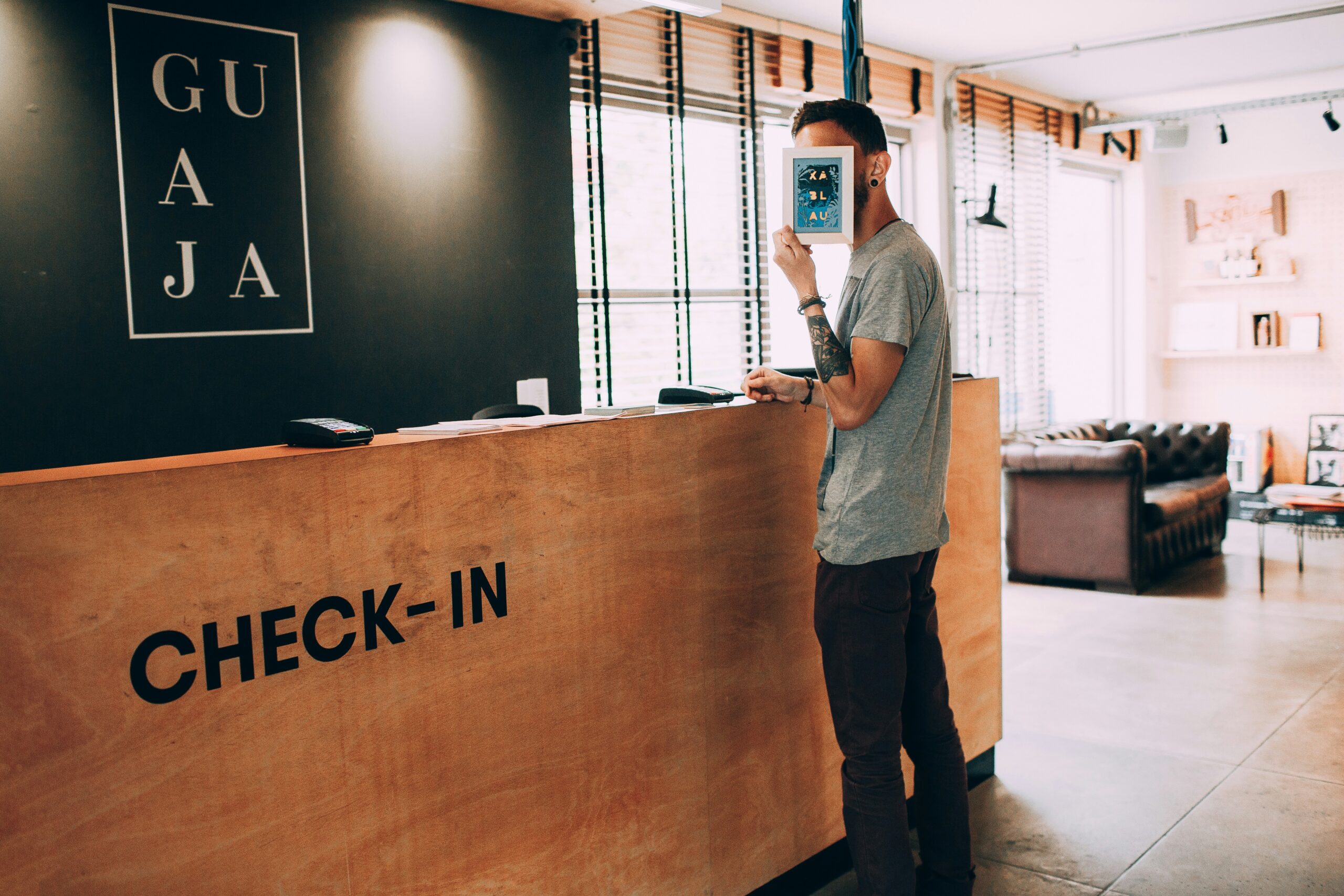 Hotel guest checking in at a front desk before reviewing possible fees, deposits, and card holds