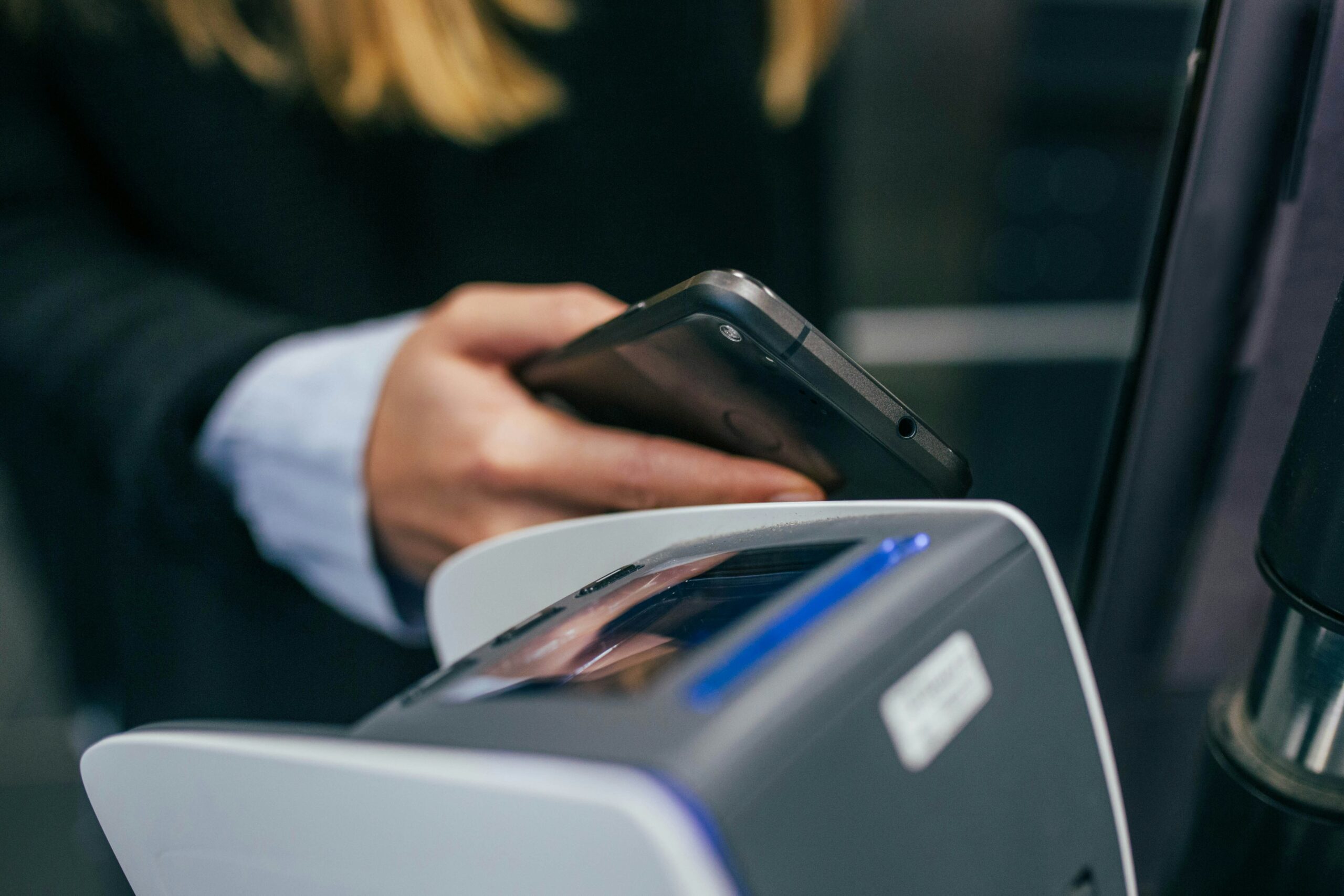 Traveler using a phone at a card payment terminal while paying abroad